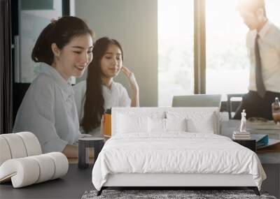 Young asian business people working with documents together at modern office Wall mural