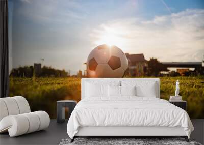 ball for street soccer football under the sunset ray light on green grass field. Film picture style Wall mural