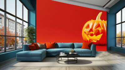 Halloween A pumpkin with a scary face is on a red background Wall mural