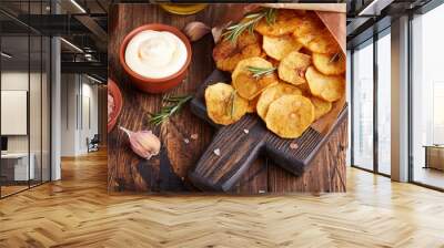 Crispy potato chips. Slices of potato, roasted with sea salt and rosemary. Delicious snack served with sauce. Fast food. Wall mural