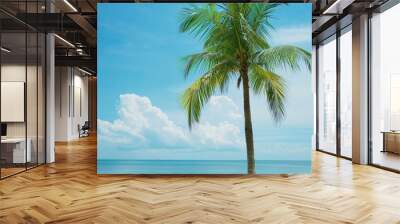 A tall palm tree with green fronds reaching toward a bright blue sky on a sunny day with scattered clouds.. Wall mural