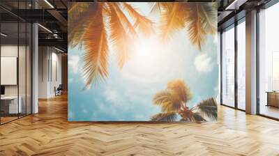 Gazing up at the blue sky and palm trees, with a vintage-style touch, creating a tropical beach and summer background with sunlights shimmering and creating a defocused effect Wall mural