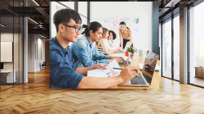 Asian business people working with laptop, searching data for business startup plan and strategy Wall mural