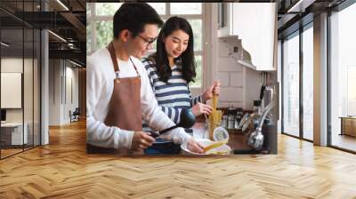 Asian couple family cooking food together in kitchen, happy family lifestyle Wall mural