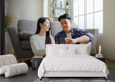 Asian couple man and woman using mobile phone, spend time together at home, Asian couple family lifestyle concept Wall mural