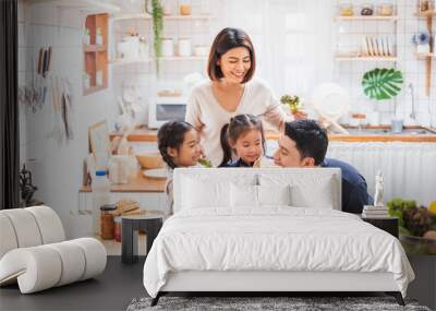 Asian family enjoy playing and cooking food in kitchen at home Wall mural