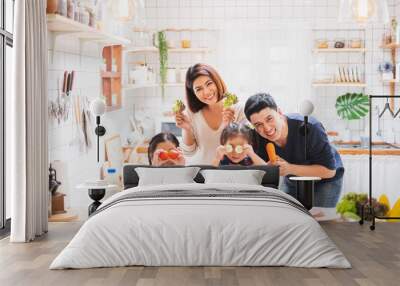 Asian family enjoy playing and cooking food in kitchen at home Wall mural