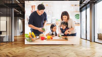 Asian family enjoy playing and cooking food in kitchen at home Wall mural