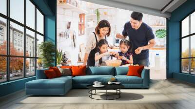 Asian family enjoy playing and cooking food in kitchen at home Wall mural