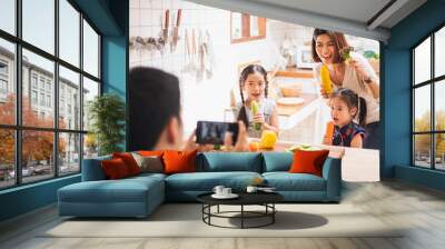 Asian family enjoy playing and cooking food in kitchen at home Wall mural