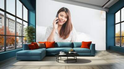 Beautiful Asian woman using laptop and smart phone in bed room for online shopping, Asian woman lifestyle concept Wall mural