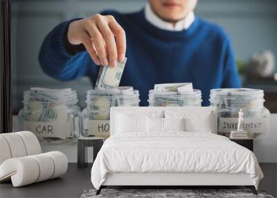 Hand's man putting money in jar for future, money plan, save money and management concept Wall mural