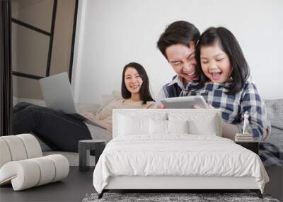 Happy Asian family spending time together at home playing game, tablet for education Wall mural