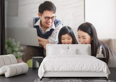 Happy Asian family using tablet, laptop for playing game watching movies, relaxing at home for lifestyle concept Wall mural