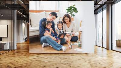 Happy Asian family using tablet, laptop for playing game watching movies, relaxing at home for lifestyle concept Wall mural