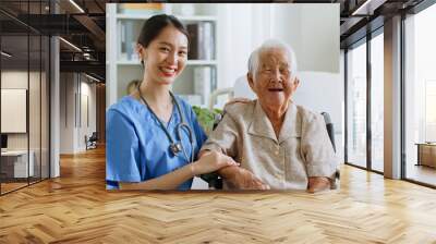 Portrait of young Asian woman, nurse, caregiver, carer of nursing home and senior Asian woman smiling and laughing at home. Look at camera Wall mural