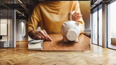 woman hand putting money bank note dollar into piggy for saving money wealth and financial concept. Wall mural