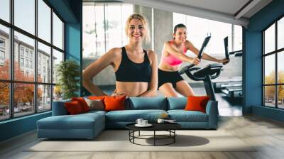 Woman workout at sport gym by cycling machine bike for cardio, gym workout concept Wall mural