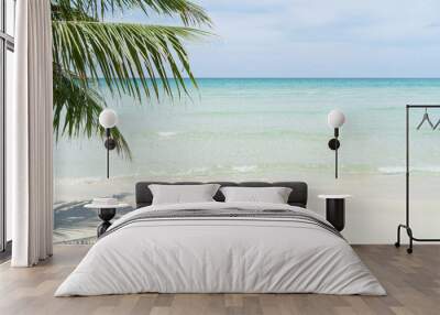 Beach for background with crystal sea and palm tree in foreground Wall mural