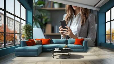 Woman in professional attire holding phone with Payment Successful text, sitting in an office chair at a desk with a laptop and notebook, showcasing online shopping and invoice Wall mural