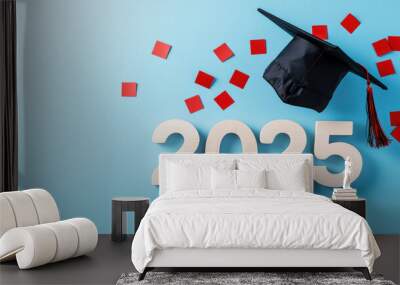 Celebrate graduation of 2025 with stylish black cap and vibrant red confetti against soft blue background, symbolizing achievement and joy Wall mural