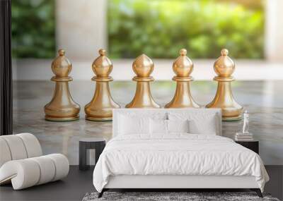 Five golden chess pieces on a marble surface with a blurred green background. Wall mural