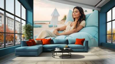 Happy woman lying down relaxing enjoying on sofa at the beach, lifestyle, generative AI Wall mural