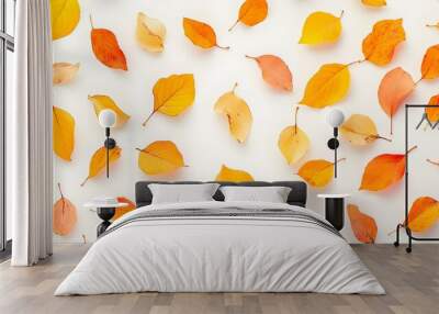 A close-up of vibrant orange and yellow autumn leaves scattered on a light solid color background, creating a serene and peaceful atmosphere Wall mural