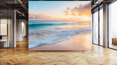 A serene beach at sunset, with gentle waves lapping at the shore and a colorful sky reflected on the water Wall mural