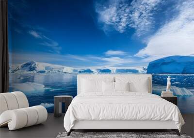 A vast expanse of icebergs floating in the crystal-clear waters of Antarctica under a bright blue sky Wall mural