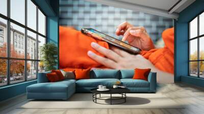 Action of a human is touching on smartphone screen for playing social, shopping online or working. Technology and business working scene photo, selective focus at finger's part. Wall mural