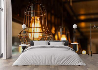 Classic designed ceiling lighting bulb with iron cage, it glowing in orange warm light shade. Object for interior decoration, close-up with selective focus. Wall mural