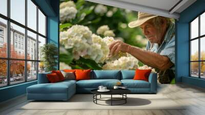 A man in a straw hat is tending to a field of white flowers Wall mural