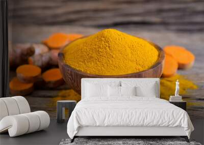 Turmeric (curcumin) powder and fresh turmeric rhizome on a wooden background,For cooking ,spices. Wall mural