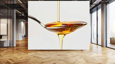 Honey dripping slowly from a spoon onto a white background, capturing the golden liquid in mid-flow. Wall mural