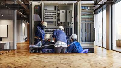 Engineer working on checking and maintenance equipment at wiring on PLC cabinet, Engineer checking status step up transformer Wall mural