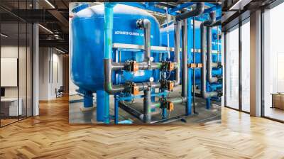 Large industrial water treatment and boiler room. Shiny steel metal pipes and blue pumps and valves. Wall mural