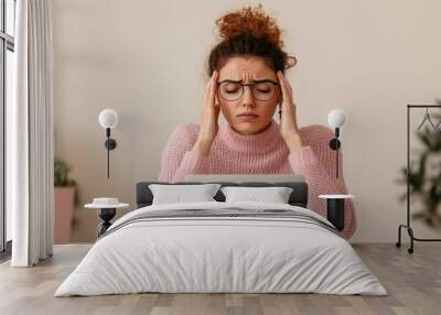 Stressed woman with laptop, indoor setting Wall mural