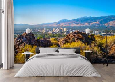 Reno autumn city skyline over Nuttall’s Rayless-Goldenrod flowers and red rock hill in the state capital of Nevada, aerial view of the arid landscape of the desert city Wall mural