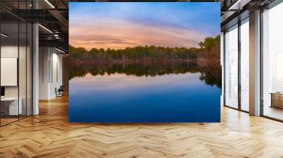 Tranquil panoramic lake and forest landscape at sunset on Cape Cod. Winter blue colors on the sky and water reflections. Wall mural