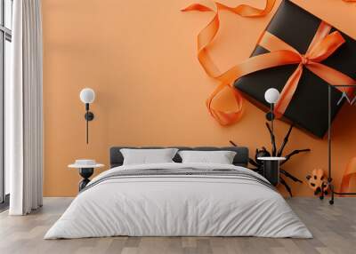 Minimalist Halloween greeting card layout featuring a spider, skull, and a small black gift box with orange ribbon, positioned on a pale orange background Wall mural