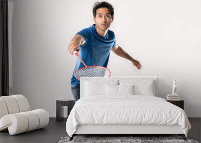 Badminton player in sportswear stands holding a racket and shuttlecock in the white background Wall mural