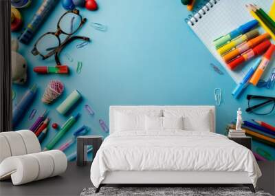 Flat lay of colorful school supplies on blue background with copy space, back to school concept featuring pencils, notebooks, and educational tools for students and teachers, top view stationery desig Wall mural