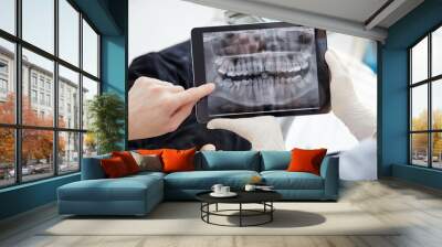 Close up woman dentist holding patient mouth digital film.The dentist explained about the oral cavity to the patient at the dental office Wall mural