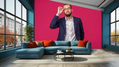 Portrait view of an attractive happy businessman with glasses on a pink background Wall mural