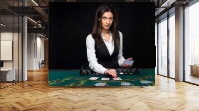 The beautiful girl, dealer, behind a table for poker Wall mural