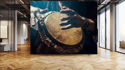 A man playing an ethnic percussion musical instrument jembe. Drummer playing african music Wall mural