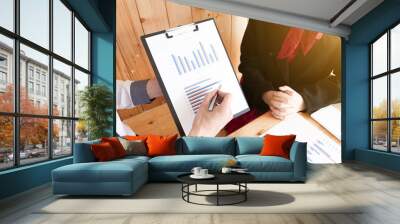 Two business people are presenting and discussing about business graph for sales plan in the office. Wall mural