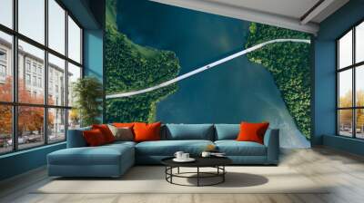 Aerial view of bridge road with red car over blue water lake or sea with island  and green woods in Finland. Wall mural