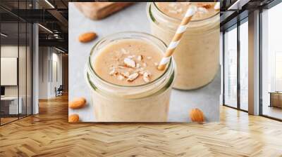 banana almond smoothie with cinnamon and oat flakes and coconut milk in glass jars Wall mural